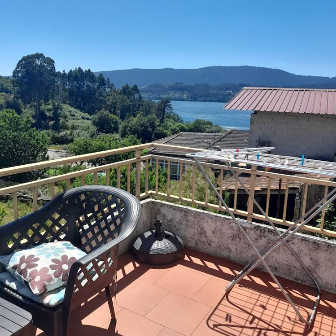Sunny terrace with chair and pillow, clear blue sky view